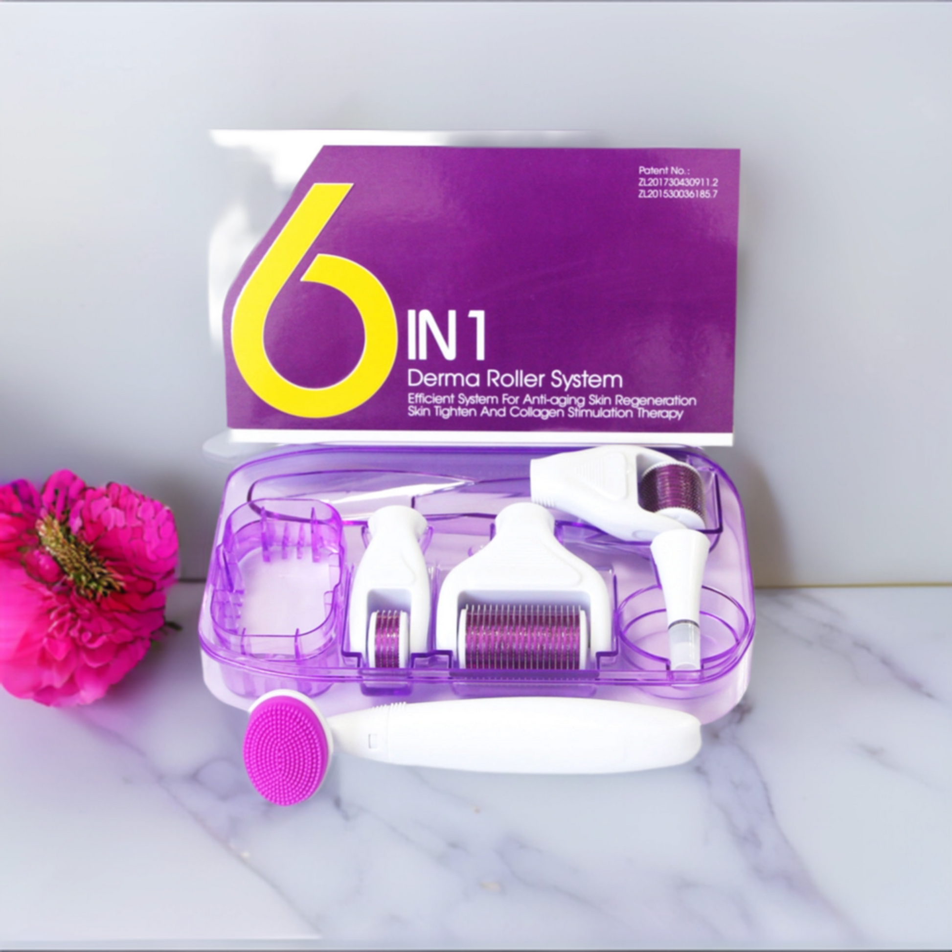 A purple box next to a pretty flower on an elegant marble table containing a 6-in-1 derma roller system.