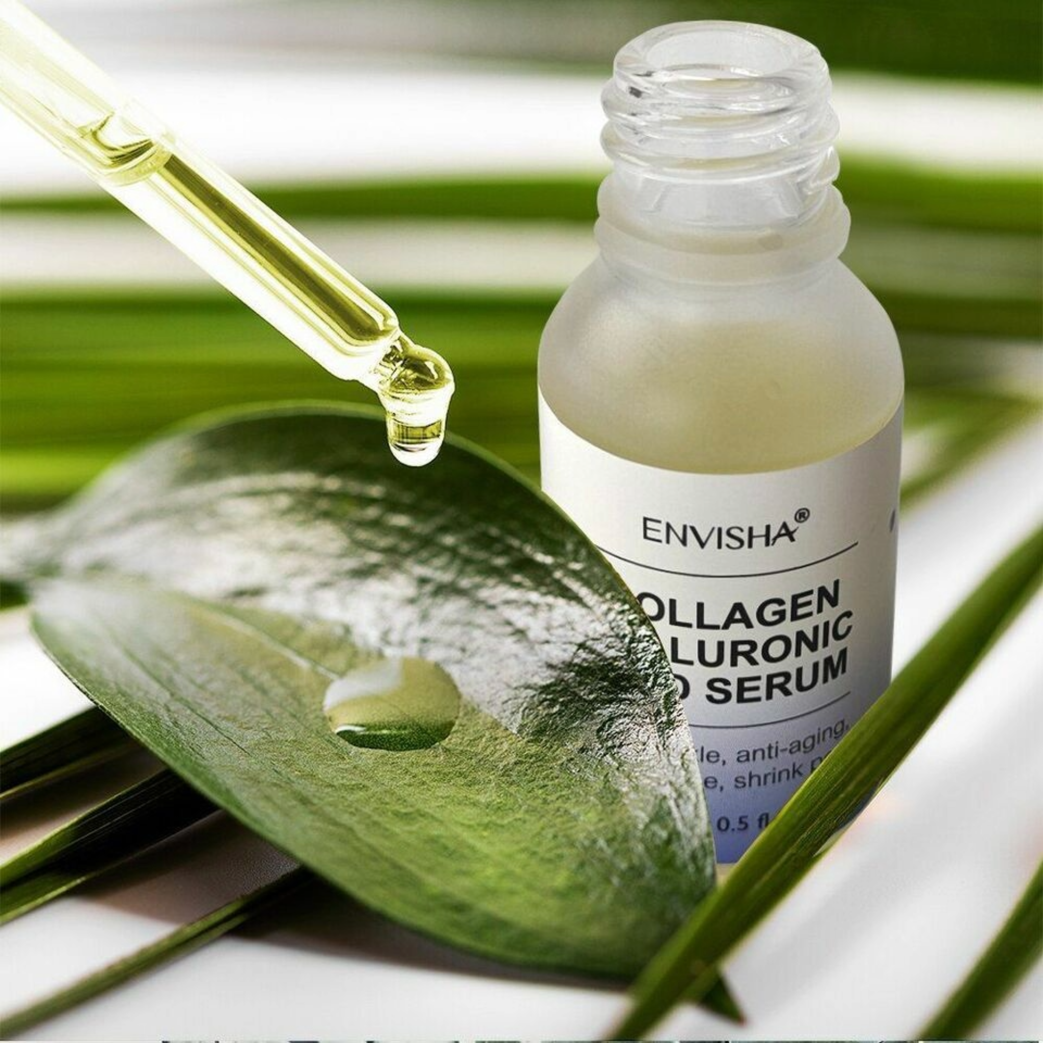 Bottle of Envisha Collagen Hyaluronic Acid Facial Serum next to green leaf and dropper.